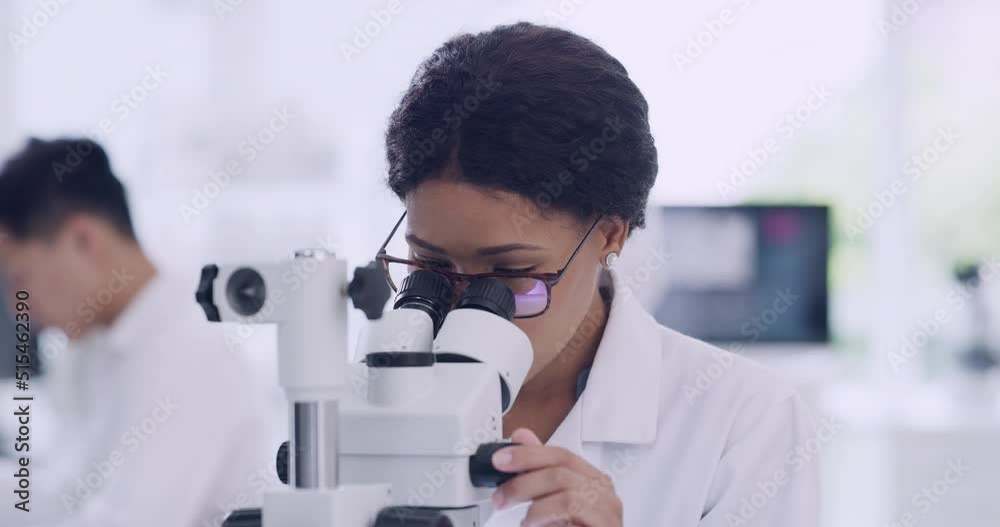 Poster Female scientist using a microscope with glasses in a research lab. Young biologist or biotechnology researcher working and analyzing microscopic samples with the latest laboratory tech equipment