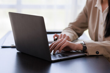 Close up Businesswoman hand typing on computer keyboard of a laptop computer in office. Business and finance concept.