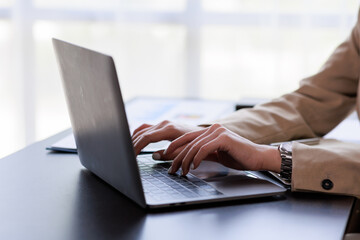Close up Businesswoman hand typing on computer keyboard of a laptop computer in office. Business and finance concept.