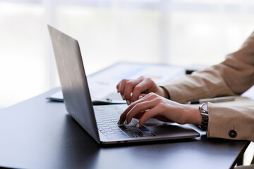 Close up Businesswoman hand typing on computer keyboard of a laptop computer in office. Business...