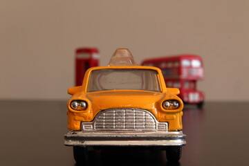 Miniature of New Yourk yellow taxi cab with Londo double bus at background