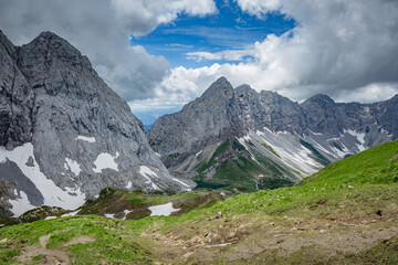 Fototapeta na wymiar Mountain hiking Trail Road. Grey sky before thunderstorm. Between Italy and Austria: near Volaia Lake Raunchkofer Mountain (Lago di Volaia Monte Rauchkofel)