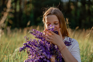 Close up portrait of young beautiful redhead woman with freckles, wearing white dress, posing in the nature. Girl with red hair holding flowers. Natural beauty. Diversity, individual uniqueness.