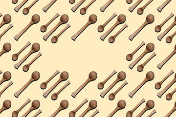 Wooden spoons, top view of wooden spoons isolated on yellow background. Kitchenware pattern with copy space.