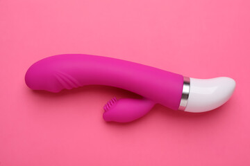 Vaginal vibrator on pink background, top view. Sex toy