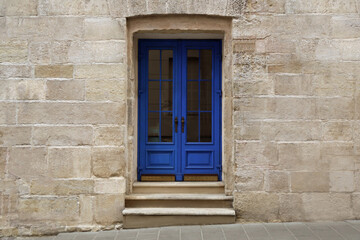 View of building with blue wooden door. Exterior design