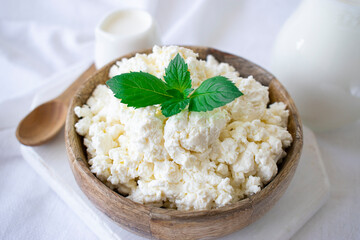 cottage cheese with mint on a white table for breakfast