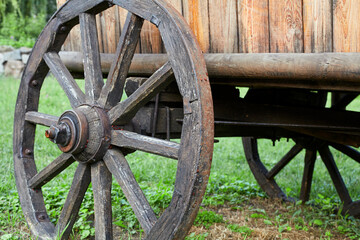 Fototapeta na wymiar Wooden wheel of vintage cart close up