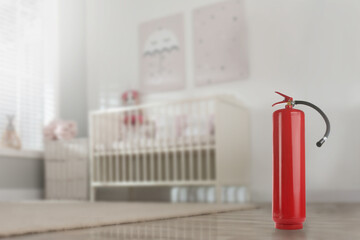 Fire extinguisher on floor in baby room. Space for text - obrazy, fototapety, plakaty