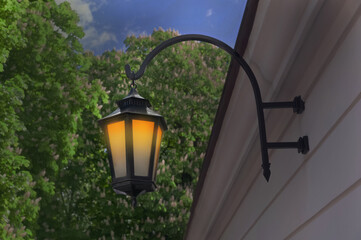 Beautiful old fashioned street lamp lighting on wall of building