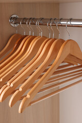 Set of clothes hangers on wardrobe rail, closeup