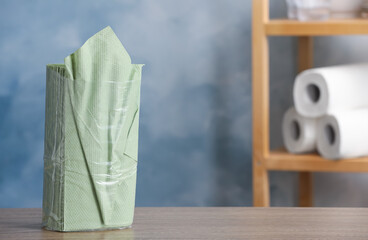 Green paper napkins on wooden table indoors. Space for text