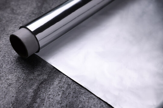 Roll Of Aluminum Foil On Grey Table, Closeup