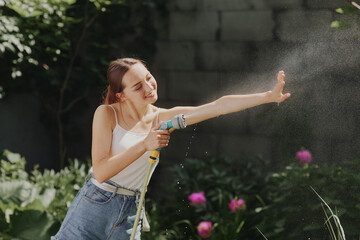 girl enjoying water in the heat of summer in the garden