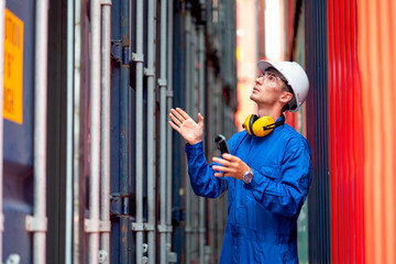 Cargo container worker or technician with safety protection and blue uniform walk to check the product in workplace and stay in channel between container tank.