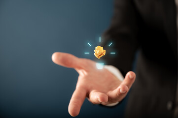 Hand of a businessman presenting a glowing lightbulb on virtual interface