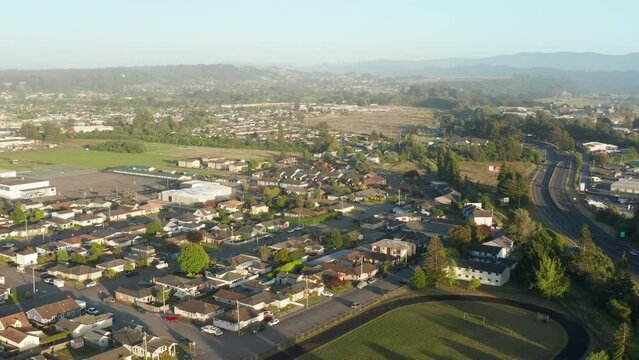 Aerial shot of Fortuna, suburban town with redwood forest mountain in background