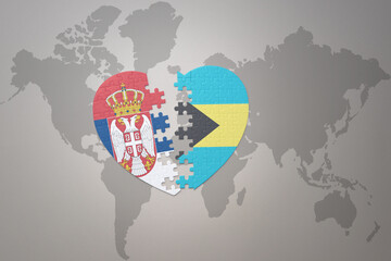 puzzle heart with the national flag of bahamas and serbia on a world map background.Concept.