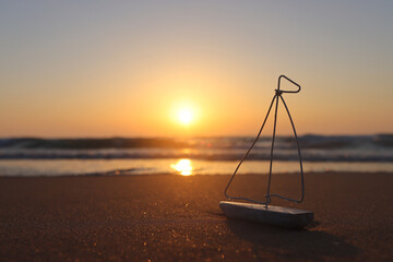 Small wooden boat on beach at summer sunset