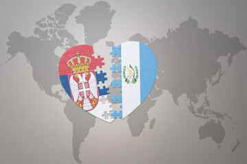 puzzle heart with the national flag of guatemala and serbia on a world map background.Concept.