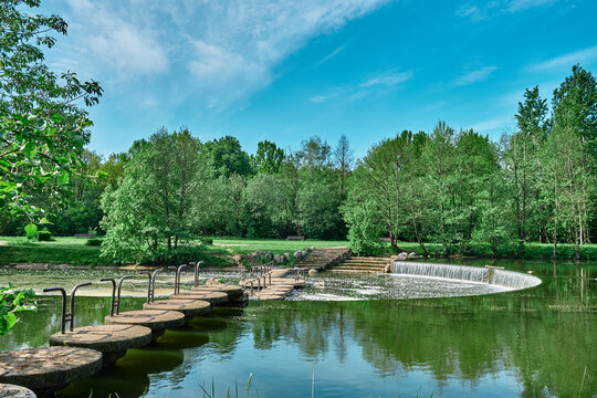 beautiful river with a bridge made of stone ang wood concreet Reflection in the water of trees landscape Water with leaves green