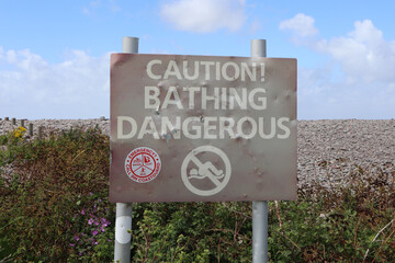 Metal sign at Bossington beach in Somerset warning that Bathing in the sea is dangerous. The sign...