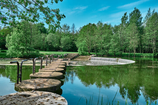 beautiful river with a bridge made of stone ang wood concreet Reflection in the water of trees landscape Water with leaves green