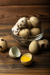Quail eggs on brown texture background.Raw eggs. Broken quail egg. Natural products. Place for text. Fresh quail eggs.