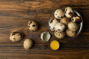 Quail eggs on brown texture background.Raw eggs. Broken quail egg. Natural products. Place for text. Fresh quail eggs.