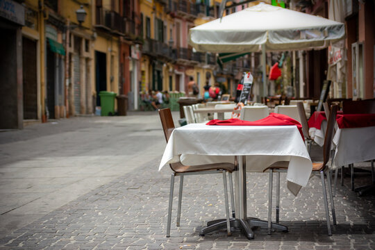Close Up on Tables and Colored Chairs on the Street Waiting to be Used by Tourists in Summer