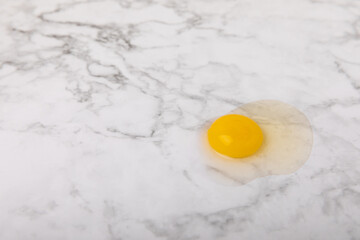 Broken quail egg on the surface. Quail eggs on a white marble background. Natural products. Place for text. fresh eggs