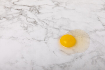 Broken quail egg on the surface. Quail eggs on a white marble background. Natural products. Place for text. fresh eggs