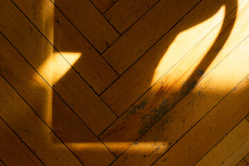 Old shabby yellow floor with sunlight shadows, horizontal photo. Background for design, wooden texture, ornament from parallel and perpendicular lines