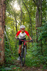 Fototapeta premium Mountain bikers ride MTB, mountain bike downhill to the extreme. Asian man rides MTB, mountain bike downhill in the wild to extremes. Extreme Sport and MTB, mountain bike downhill Concept.