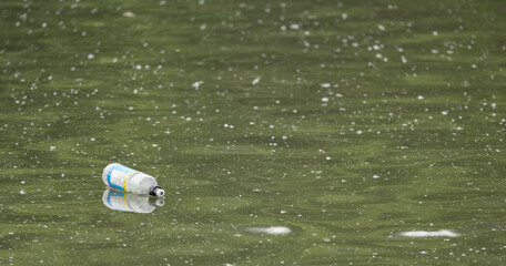 Newcastle-under-Lyme, Staffordshire-united kingdom April, 14, 2022 popular fizzy drink PET plastic bottle float on water surface pollution concept