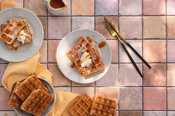 Viennese waffles with cottage cheese and fruit sauce and decorated with powdered sugar. Photo of Viennese waffles on the kitchen table. The concept of a sweet breakfast. Top view. 