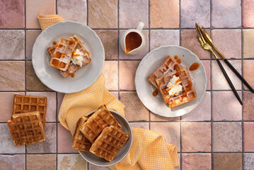 Viennese waffles with cottage cheese and fruit sauce and decorated with powdered sugar. Photo of Viennese waffles on the kitchen table. The concept of a sweet breakfast. Top view. 