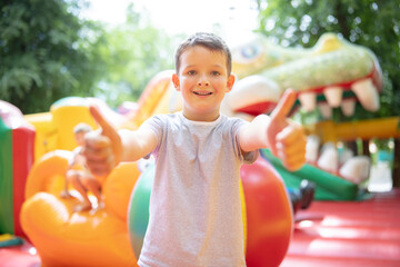 Happy boy having a lots of fun on a colorful inflate castle. Colorful playground. Activity and play...