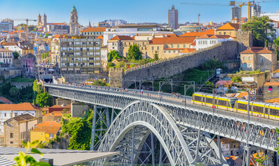 Beautiful view of Dom Luis Bridge over Douro River in Portuguese city Porto with running metro...
