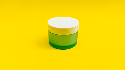 cup of cosmetics on yellow background isolated