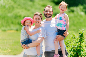 Fototapeta premium Portrait of a young happy family having fun outdoors