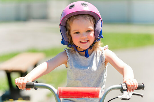 Children Learning To Drive A Bicycle On A Driveway Outside. Little Girls Riding Bikes On Asphalt.