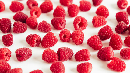 Fresh red raspberries on a white table background