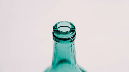 Glass transparent green bottle for liquids without the cap on a white background