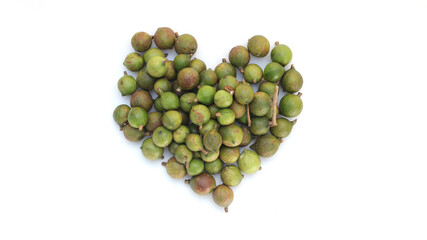 Macadamia nuts on heart shaped isolated on white background