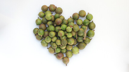 Macadamia nuts on heart shaped isolated on white background