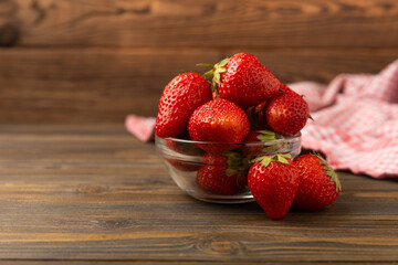 Fresh ripe strawberries in a bowl on a brown texture background.Vegetarian organic berry.Healthy food.Copy space.Place for text
