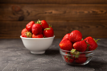 Fresh ripe strawberries in a plate on a black texture background.Vegetarian organic berry.Healthy food.Vitamins.Copy space.Place for text
