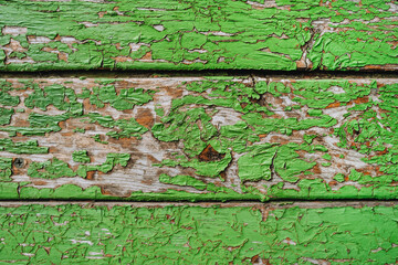 Background, texture of a wooden door, walls made of old cracked boards in green paint. © shchus