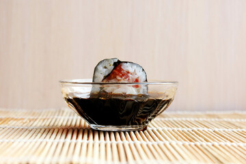 Fresh sushi roll on a light background. Sushi in a saucer with soy sauce. Snack, lunch. Asian cuisine. Meal. Copy space